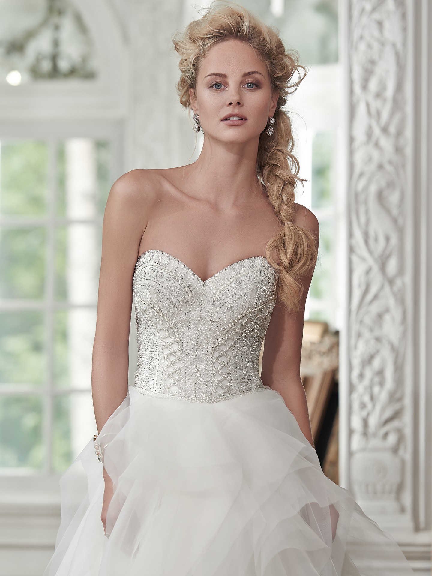 Lightweight tulle and Chic organza create the breathtaking skirt of the Ohara ball gown wedding dress, with sparkling beaded bodice and romantic sweetheart neckline completing the look. Finished with covered buttons over zipper and inner corset closure.