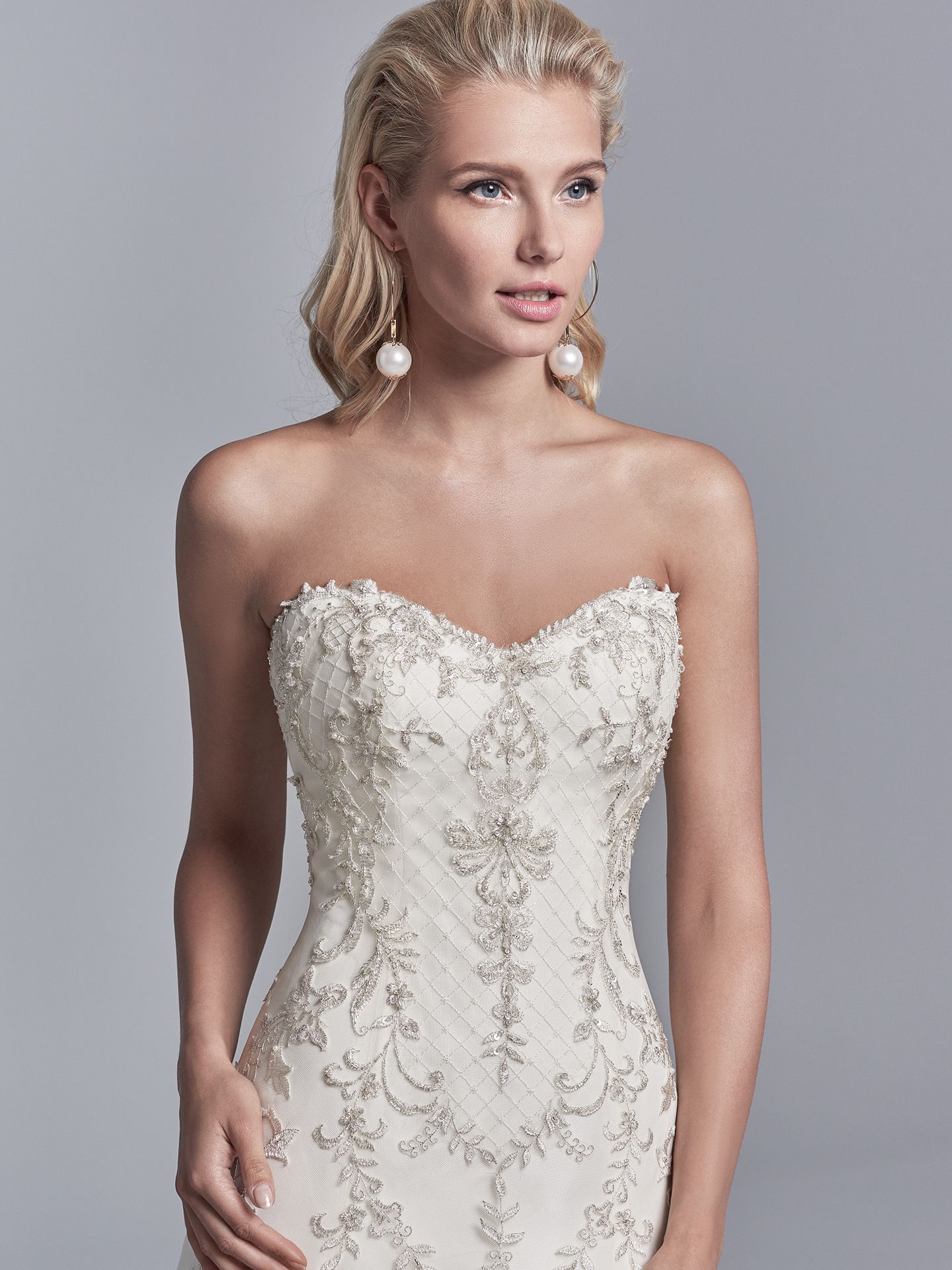 Granger by Sottero and Midgley. Embroidered lace motifs and Swarovski crystals dance over this tulle and Soft Shimmer Satin A-line wedding gown, featuring a strapless sweetheart neckline, illusion scoop back accented in beaded lace motifs, and crosshatch detail through the hemline. 10 Top-Pinned Sottero and Midgley Gowns of 2017.