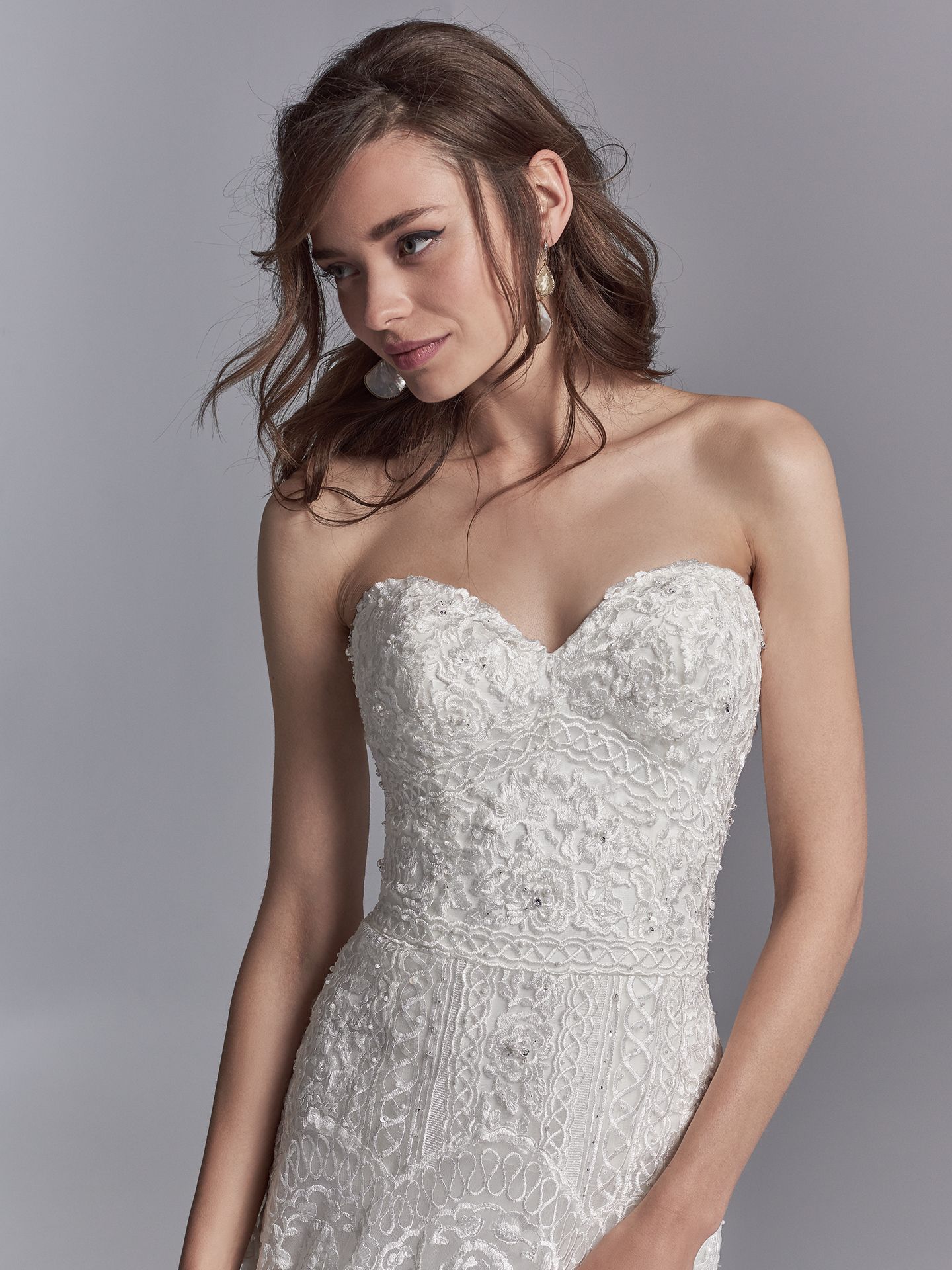 Skylar by Sottero and Midgley. Embroidered lace motifs accented in beading and Swarovski crystals cascade over tulle in this sheath wedding dress, completing the strapless sweetheart neckline and scallop lace hemline. 10 Top-Pinned Sottero and Midgley Gowns of 2017.